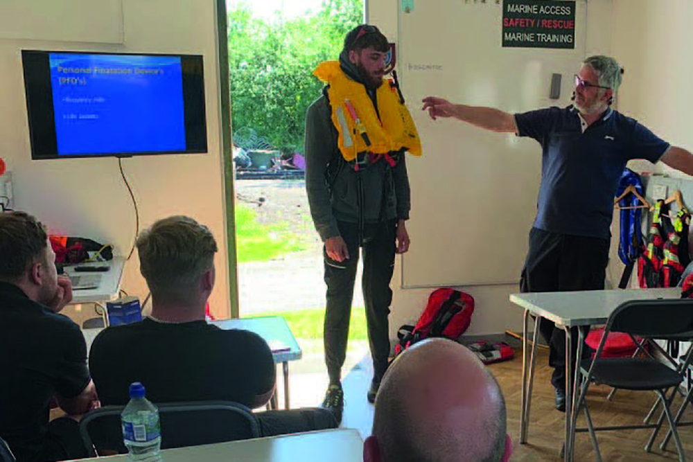 Instructor demonstrates a lifejacket during British Marine Foundation in Water Safety classroom training.