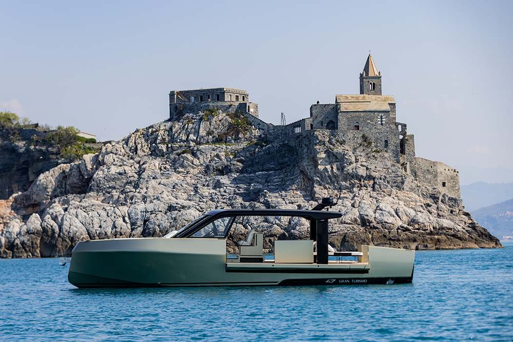 Forte 47 Gran Turismo at anchor off rocky coast with historic church above turquoise water