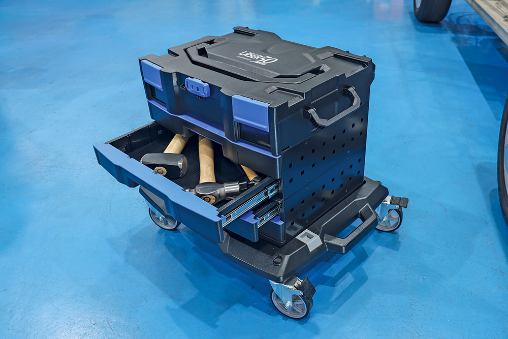 Laser Tools modular workshop storage trolley with open drawer holding soft-faced hammers on a wheeled workshop floor.