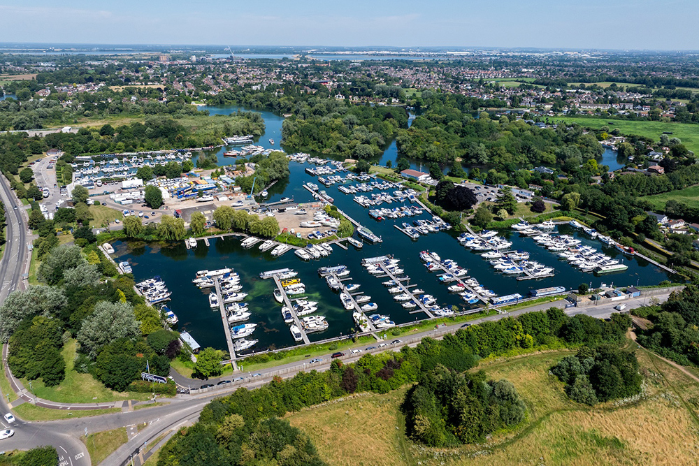 Aerial view of Penton Hook Marina on the River Thames, showing pontoons, boats and surrounding greenery.