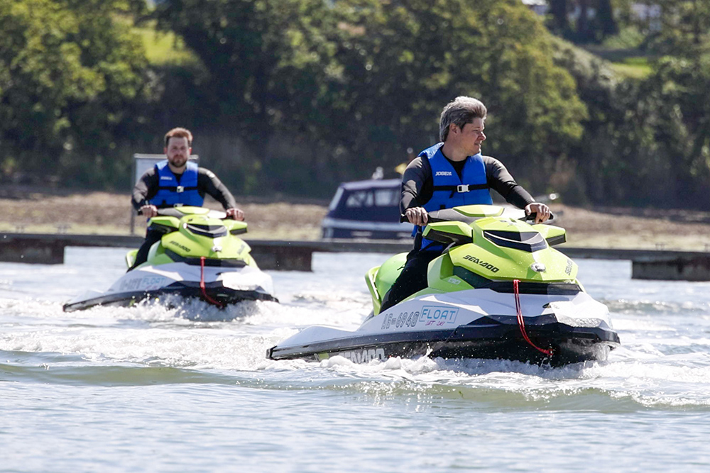 Two riders manoeuvre Sea-Doo jet skis near docking pods at Cobb’s Quay Marina.