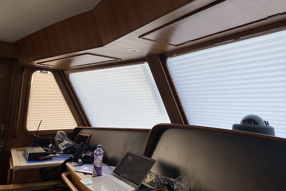 Dometic pleated yacht blinds fitted across a wooden wheelhouse interior
