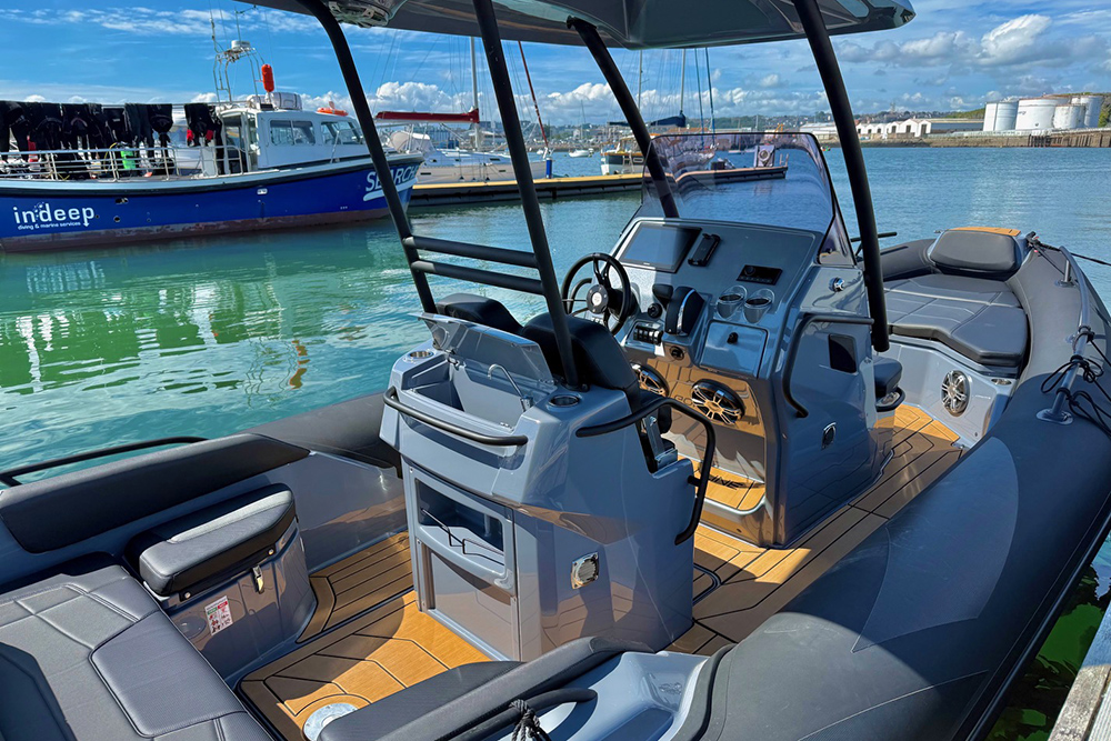 RIB cockpit on display at Plymouth Boat Fest, moored beside commercial vessels in the marina.