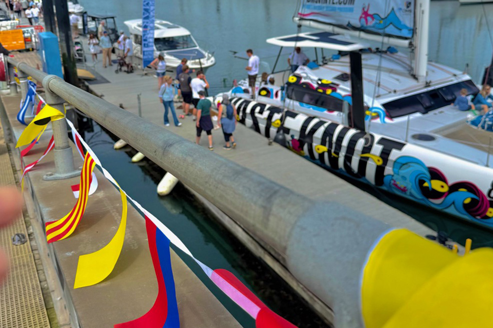 Visitors on the Plymouth Boat Fest pontoons beside decorated boats and marina bunting.