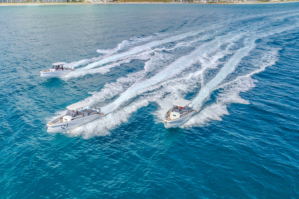 Three Steak powerboats underway off the coast, leaving sweeping wakes during a high-speed sea trial.