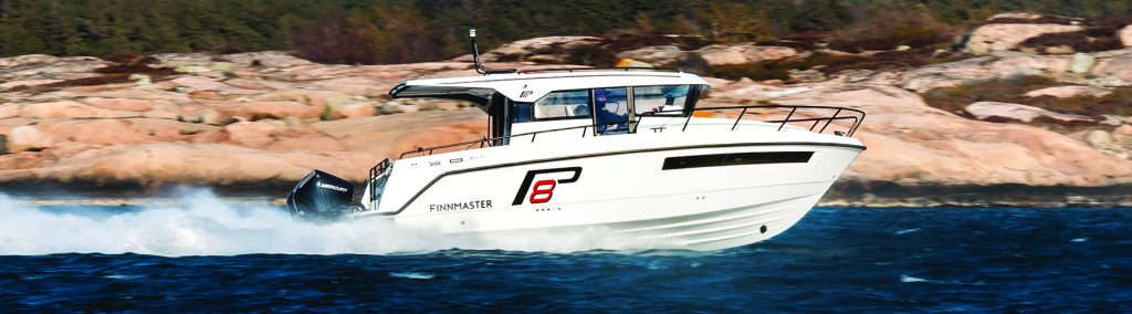 Finnmaster P8 pilothouse underway at speed with rocky coastline behind