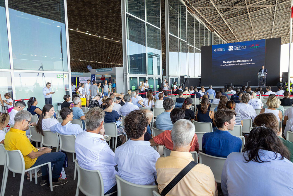 Audience attending a presentation at the Genoa Boat Show forum inside the exhibition hall.