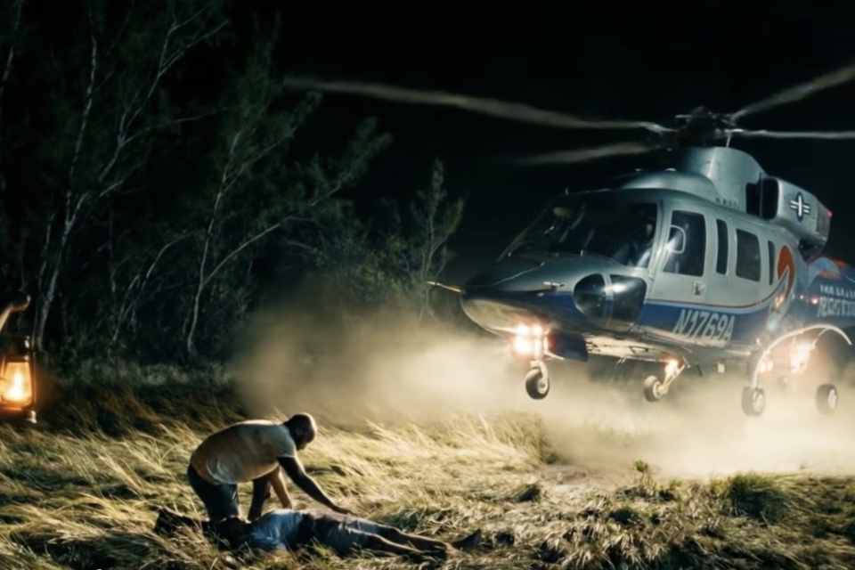 Tropic Air Rescue helicopter landing at night as responders attend a patient during an emergency evacuation.