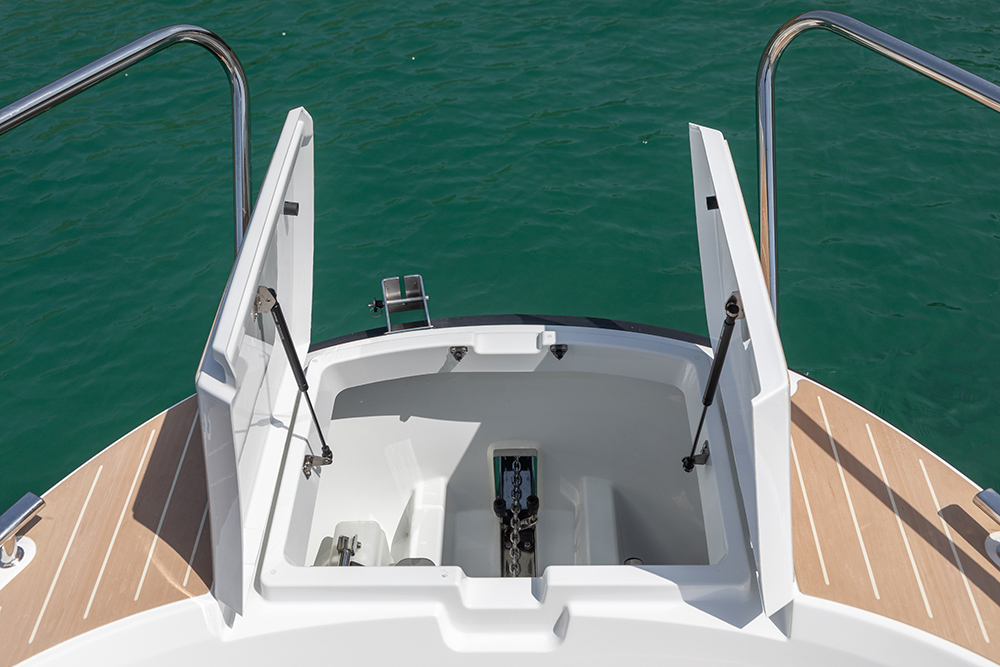 Bow of motorboat showing open anchor locker.