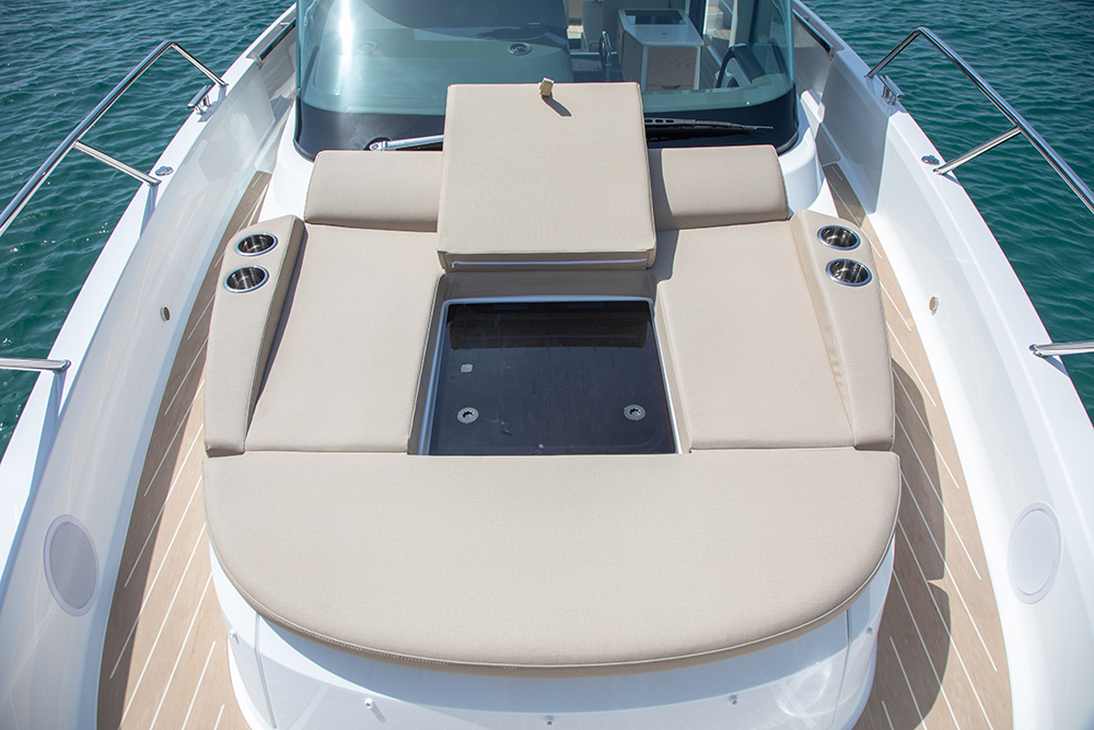 beige sunbed with lifted cushion showing the sky.ight underneath for the master cabin