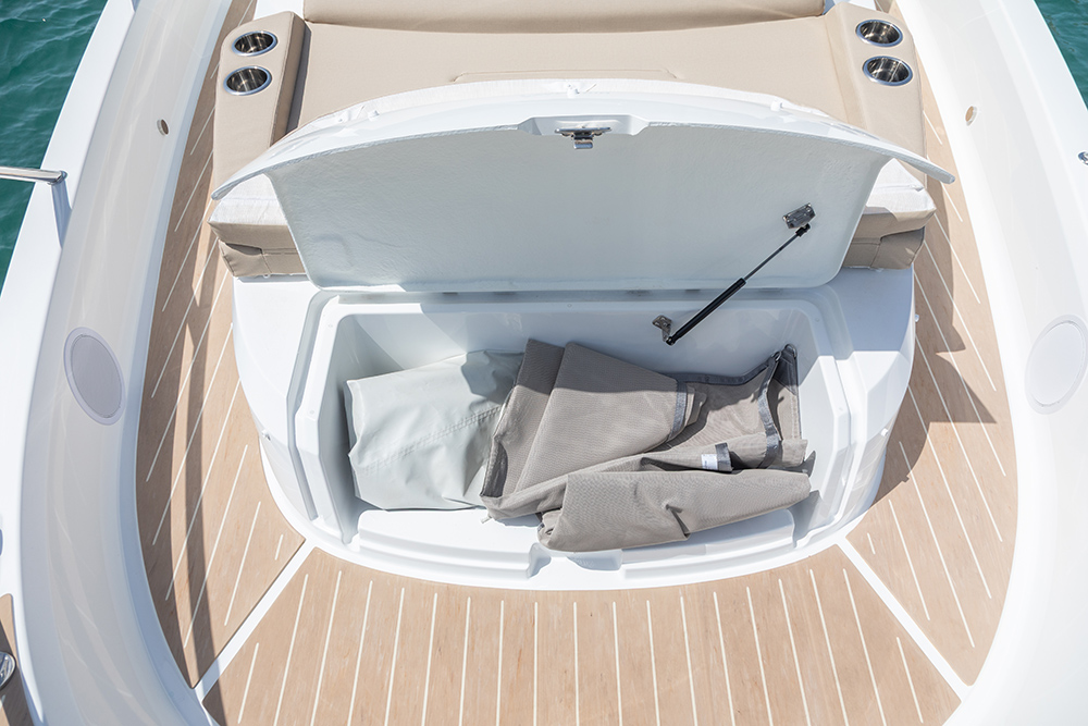 Locker opening up under bow sun bed showing storage items inside