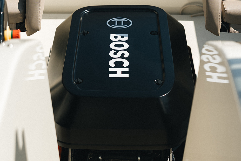 Close-up of the Bosch-branded EDM electric drive housing installed between two seats aboard a demo boat.