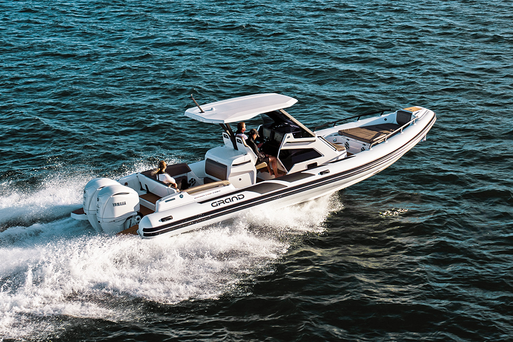 Grand G980 RIB with T-top and twin outboards underway at sea