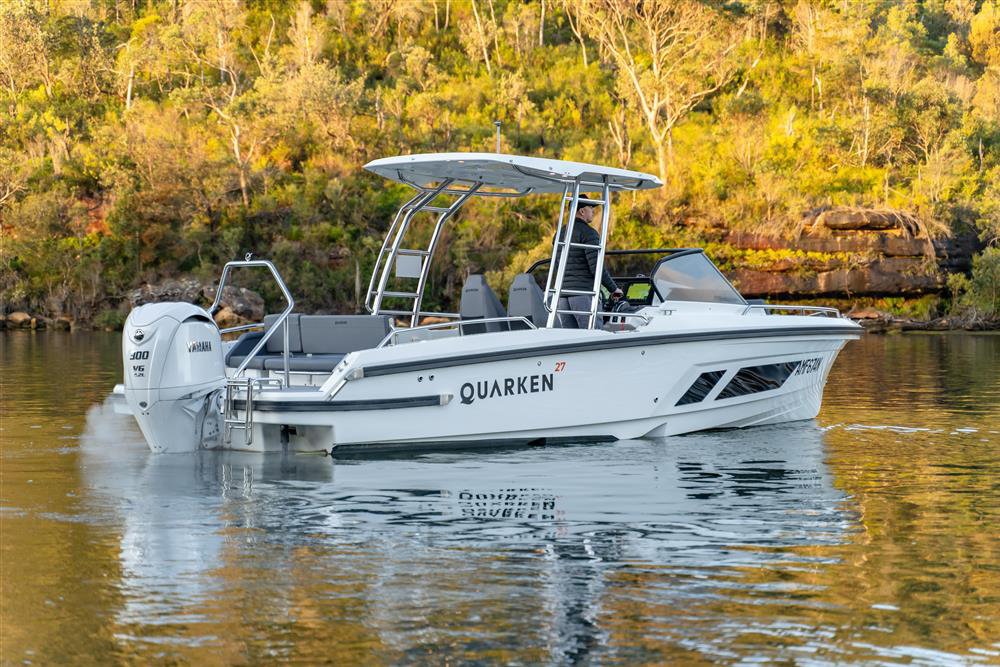 Quarken 27 T-Top powerboat with Yamaha outboard cruising on calm water beside a wooded shoreline