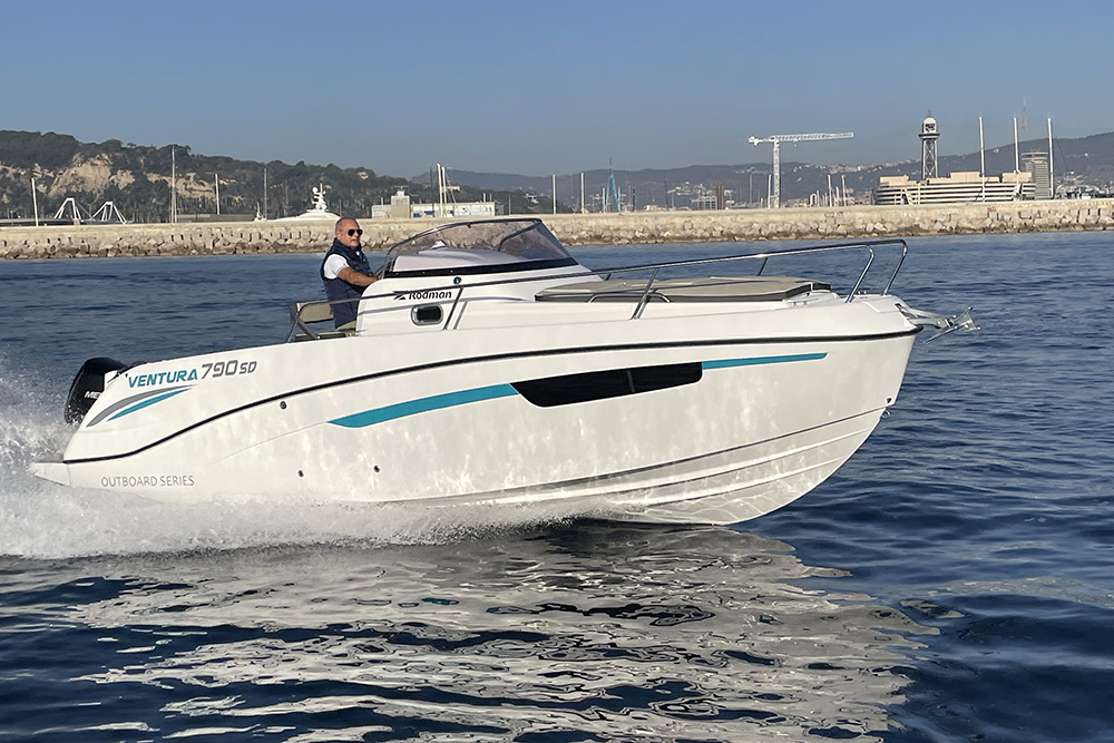 Rodman 790 Ventura SD outboard day boat at speed on the water, driver at the helm, harbour behind.
