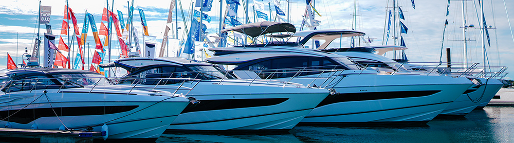 Row of motoryachts side by side with show flags in the background