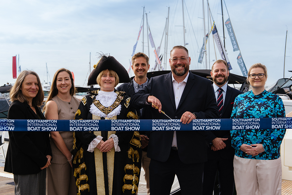 Ribbon-cutting at Southampton International Boat Show, with a robed civic dignitary and guests beside the marina yachts.