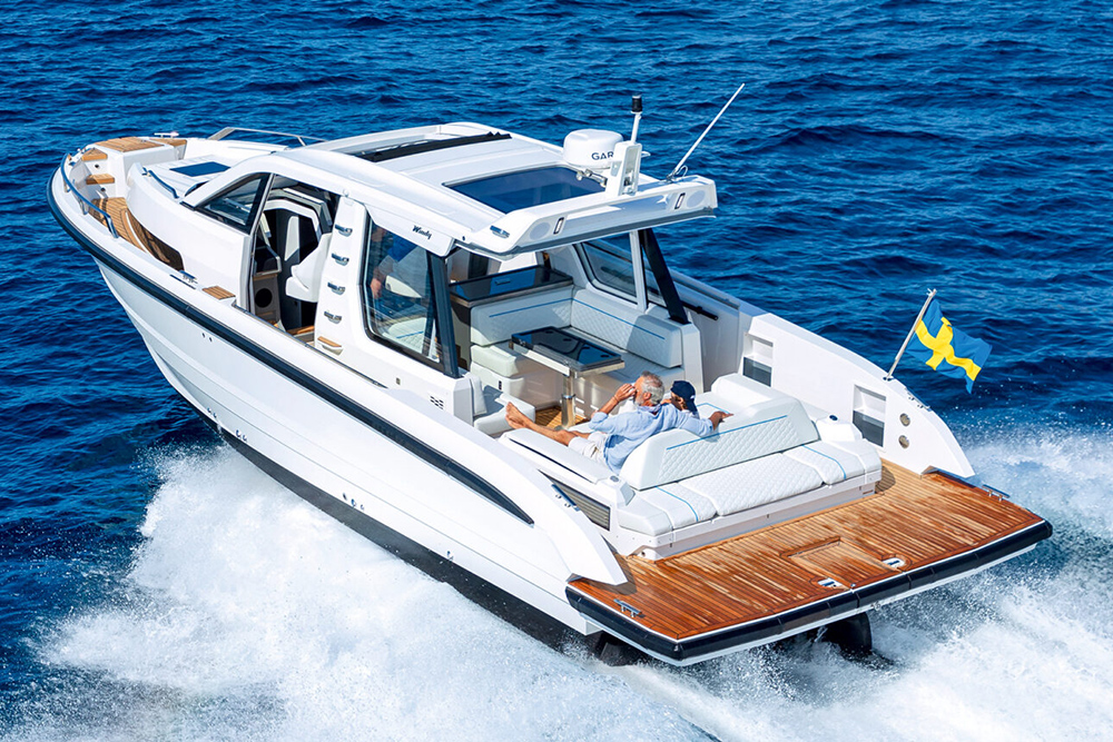 Windy SR40 performance boat underway at speed, with Swedish flag and teak swim platform visible.