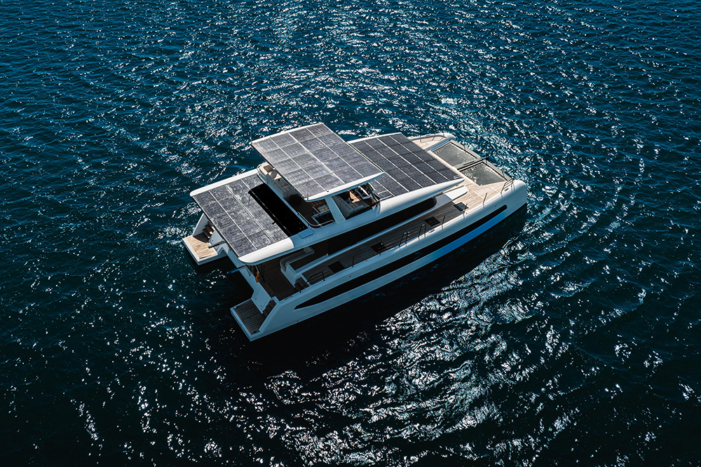Aerial view of the Pioneer Yachts PY60 catamaran on deep blue water, its roof and hardtop covered in solar panels.