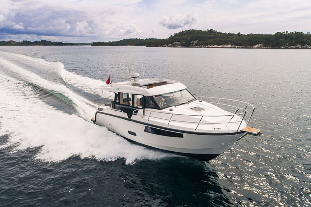 Viknes S35 Panorama wheelhouse cruiser underway off a wooded coastline, showing its sweeping glazing and raked bow.