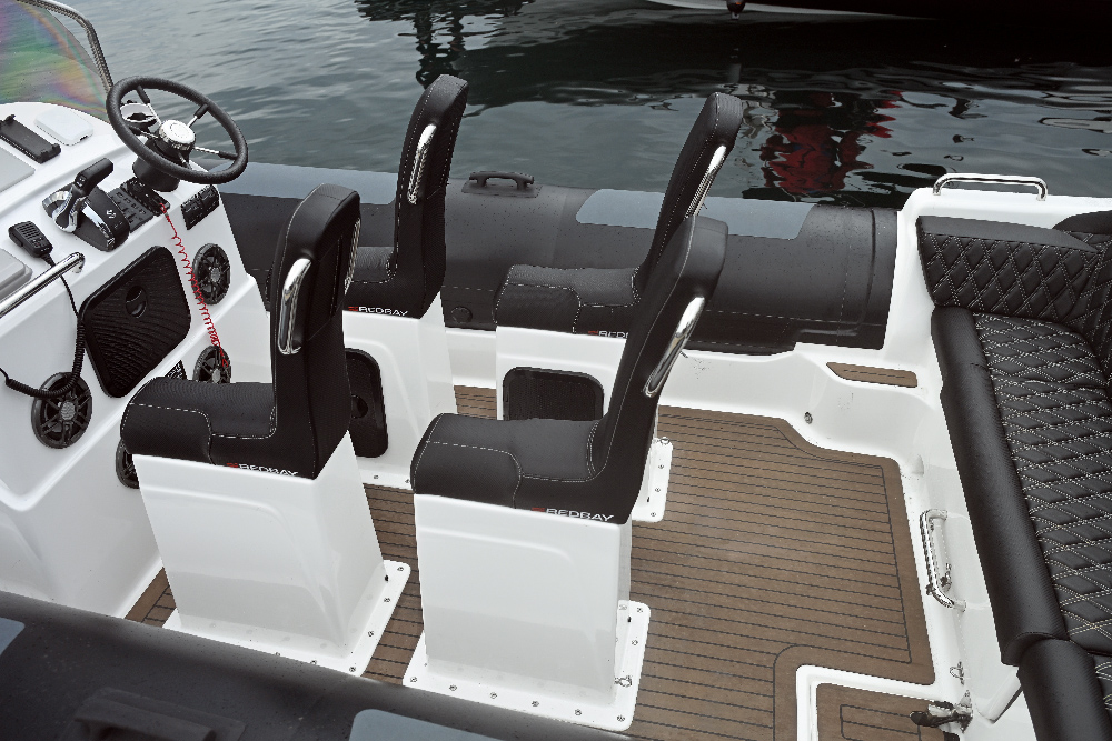 Redbay SF750 sit-astride seat pods with grab handles beside the helm console and faux-teak deck